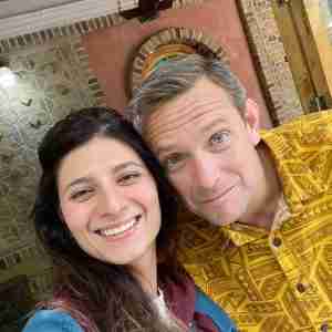 A selfie group photo of a man and a woman who are smiling 